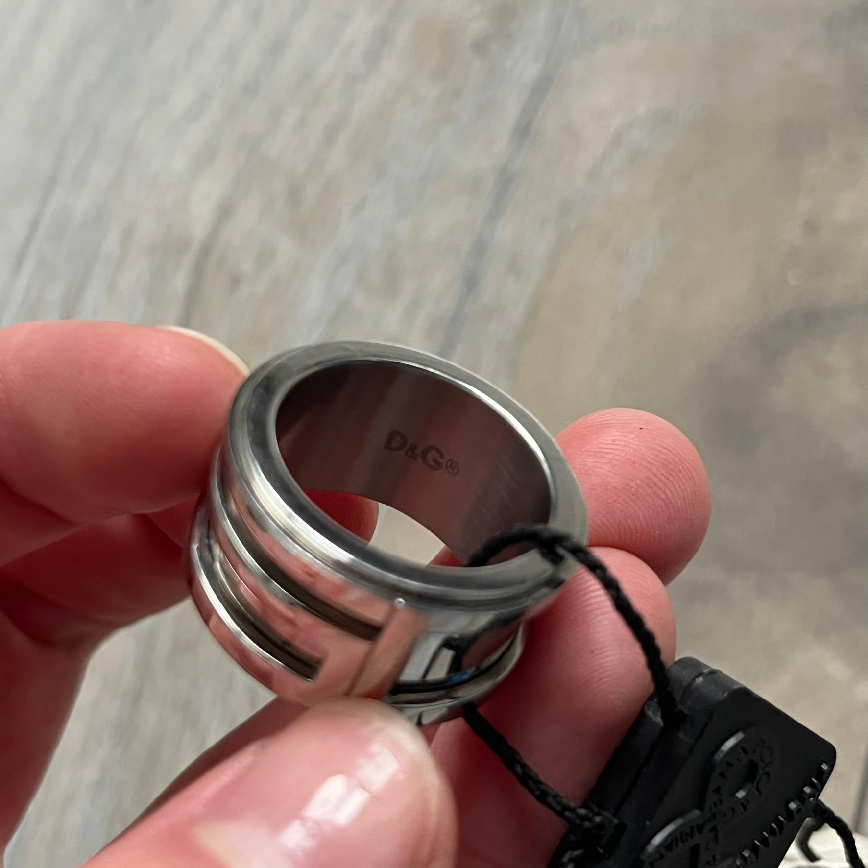 Dolce &amp; Gabbana 3D logo ring crafted in silver-tone metal with a unique two-part construction. The base is a classic band, topped with a raised layer that wraps the D&amp;G logo around the ring. Designed with a movable top section that spins, it’s a dynamic accessory merging playful function with signature branding.