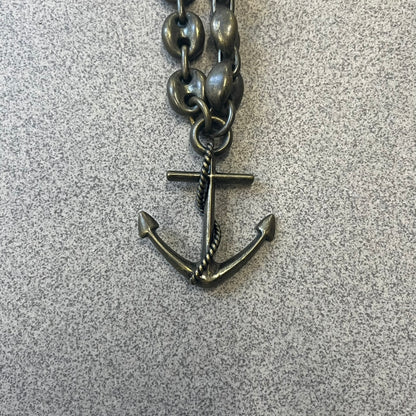 Dolce &amp; Gabbana AW2006 Anchor Necklace features a thick, heavy necklace with a dirty gold-tone finish and oversized mariner links. One of the links is detailed with an engraved D&amp;G logo plaque. The main pendant is a large anchor wrapped with a rope motif, matching the rugged nautical-inspired design of the necklace.