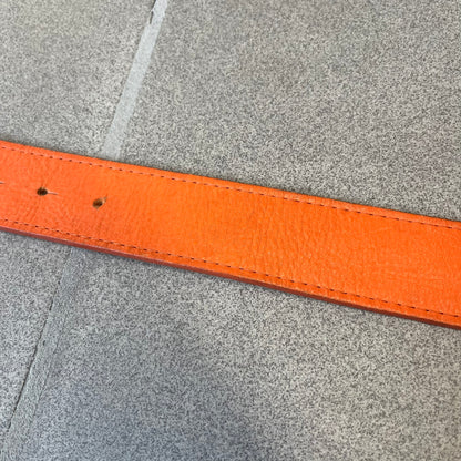 Dolce &amp; Gabbana 2008 Butterfly Buckle Orange Leather Belt from the AW2008 collection. Crafted from smooth orange leather with visible edge stitching, this belt features a big silver-tone D&amp;G logo buckle shaped in a butterfly-style form. The buckle has a polished metal finish, while the belt itself is made from 100% leather and retains a clean, structured profile. An original seasonal accessory from Dolce &amp; Gabbana’s AW2008 season.
