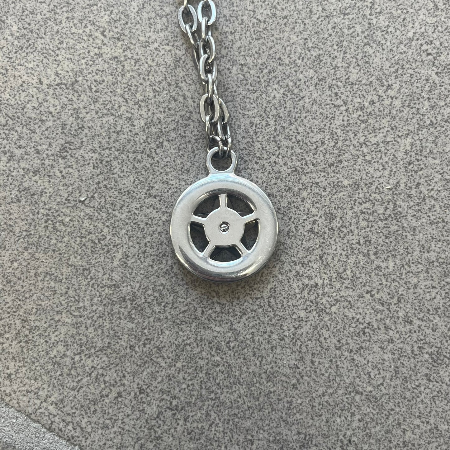Dolce &amp; Gabbana AW2009 Military Star Necklace in grey. Features a 3D black star mounted on a silver-tone metal circle with an engraved D&amp;G logo at the bottom, suspended from a silver cable chain. Lobster clasp with small D&amp;G markings.