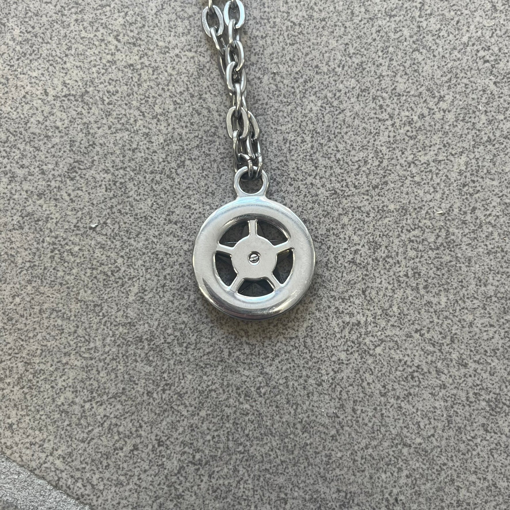 Dolce &amp; Gabbana AW2009 Military Star Necklace in grey. Features a 3D black star mounted on a silver-tone metal circle with an engraved D&amp;G logo at the bottom, suspended from a silver cable chain. Lobster clasp with small D&amp;G markings.