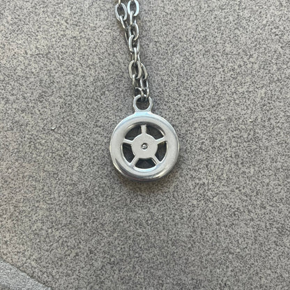 Dolce &amp; Gabbana AW2009 Military Star Necklace in grey. Features a 3D black star mounted on a silver-tone metal circle with an engraved D&amp;G logo at the bottom, suspended from a silver cable chain. Lobster clasp with small D&amp;G markings.
