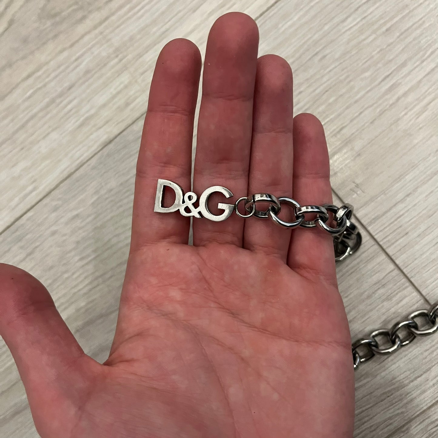 Dolce &amp; Gabbana Carabiner Chain Necklace features a robust stainless steel chain with a central carabiner engraved with the D&amp;G logo. The adjustable design includes a bolt-style clasp to modify the length, and the opposite end showcases a three-dimensional D&amp;G logo, blending industrial detailing with high-fashion appeal.