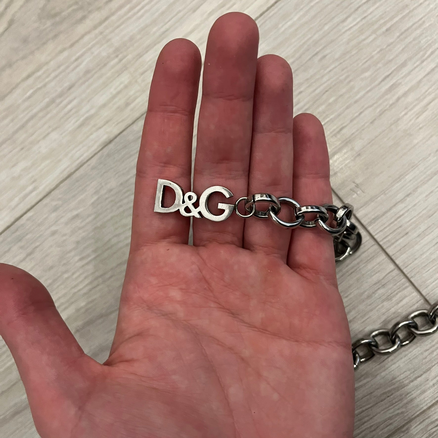 Dolce &amp; Gabbana Carabiner Chain Necklace features a robust stainless steel chain with a central carabiner engraved with the D&amp;G logo. The adjustable design includes a bolt-style clasp to modify the length, and the opposite end showcases a three-dimensional D&amp;G logo, blending industrial detailing with high-fashion appeal.