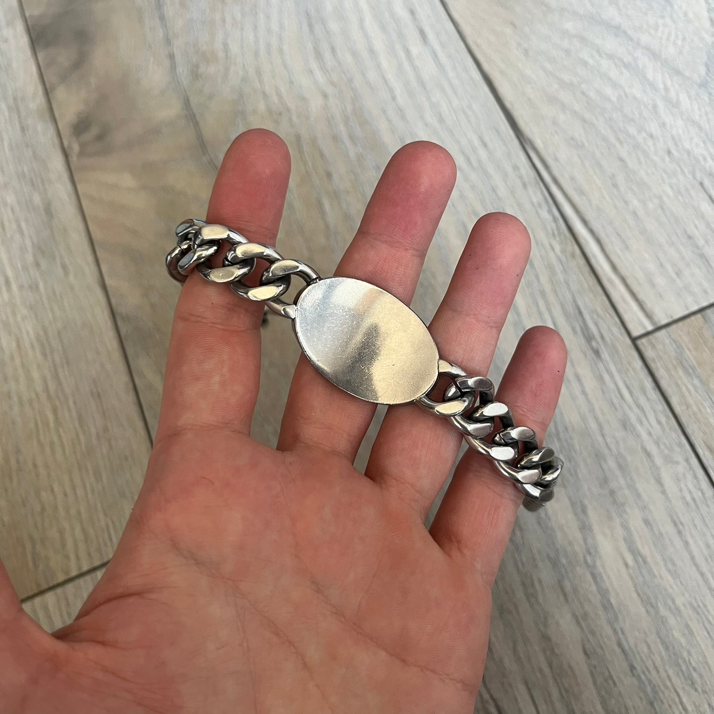 Dolce &amp; Gabbana Champagne Bracelet DJ1092 is a stainless steel bracelet. The silver-tone metal plate is shaped like a D&amp;G champagne label and displays a black D&amp;G logo, along with engraved “Glamorous Champagne 1994 Alc. 12% by Vol.” text. The back of the plate features a large, shallow engraved D&amp;G logo. Retailed at 125 usd in 2000's.