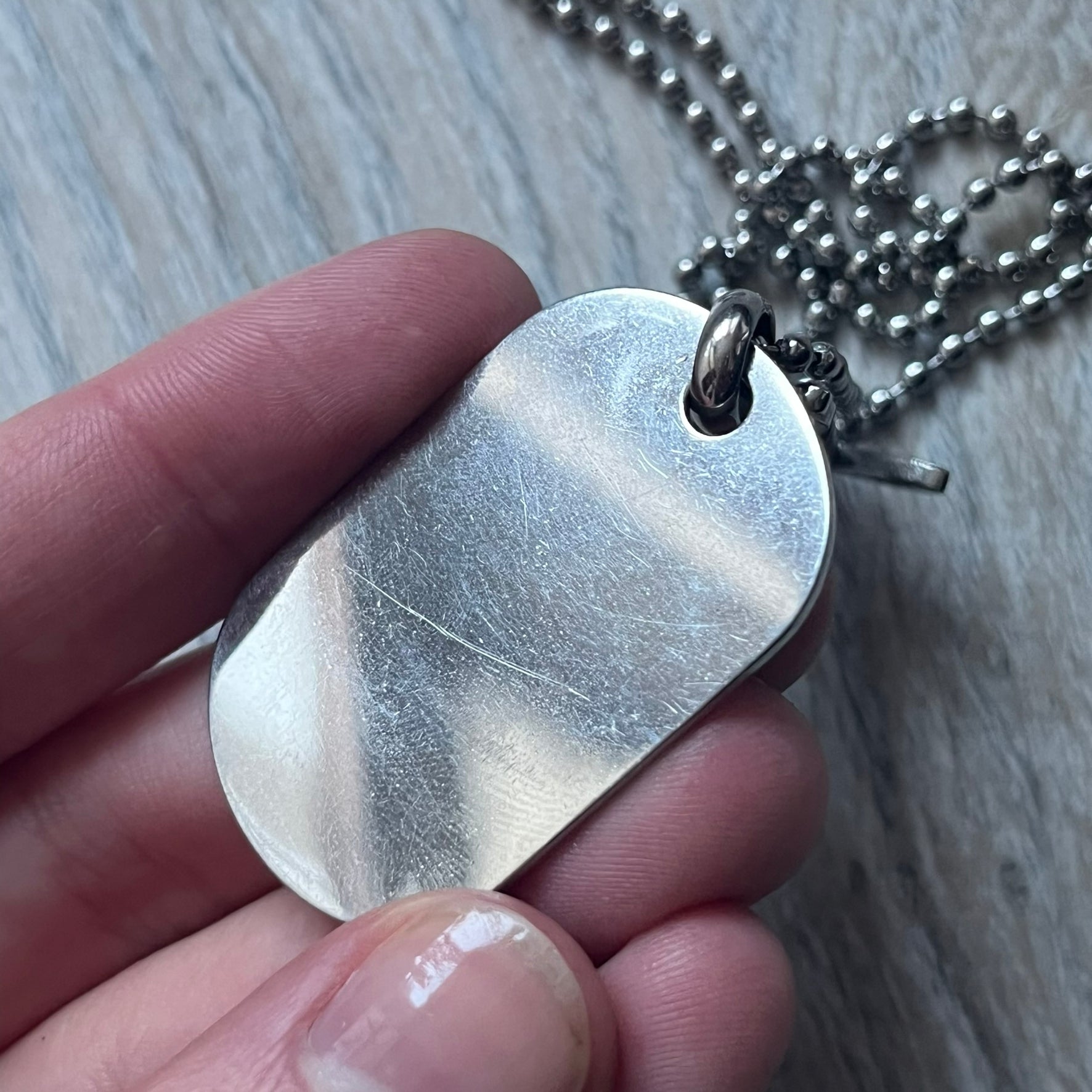 The Dolce & Gabbana Crystal Logo Dog Tag Necklace features a silver-tone ball chain with two pendants: a plain dog tag and a cutout D&G logo adorned with crystals. It has a large clasp engraved with D&G and model markings, from the 2000s.