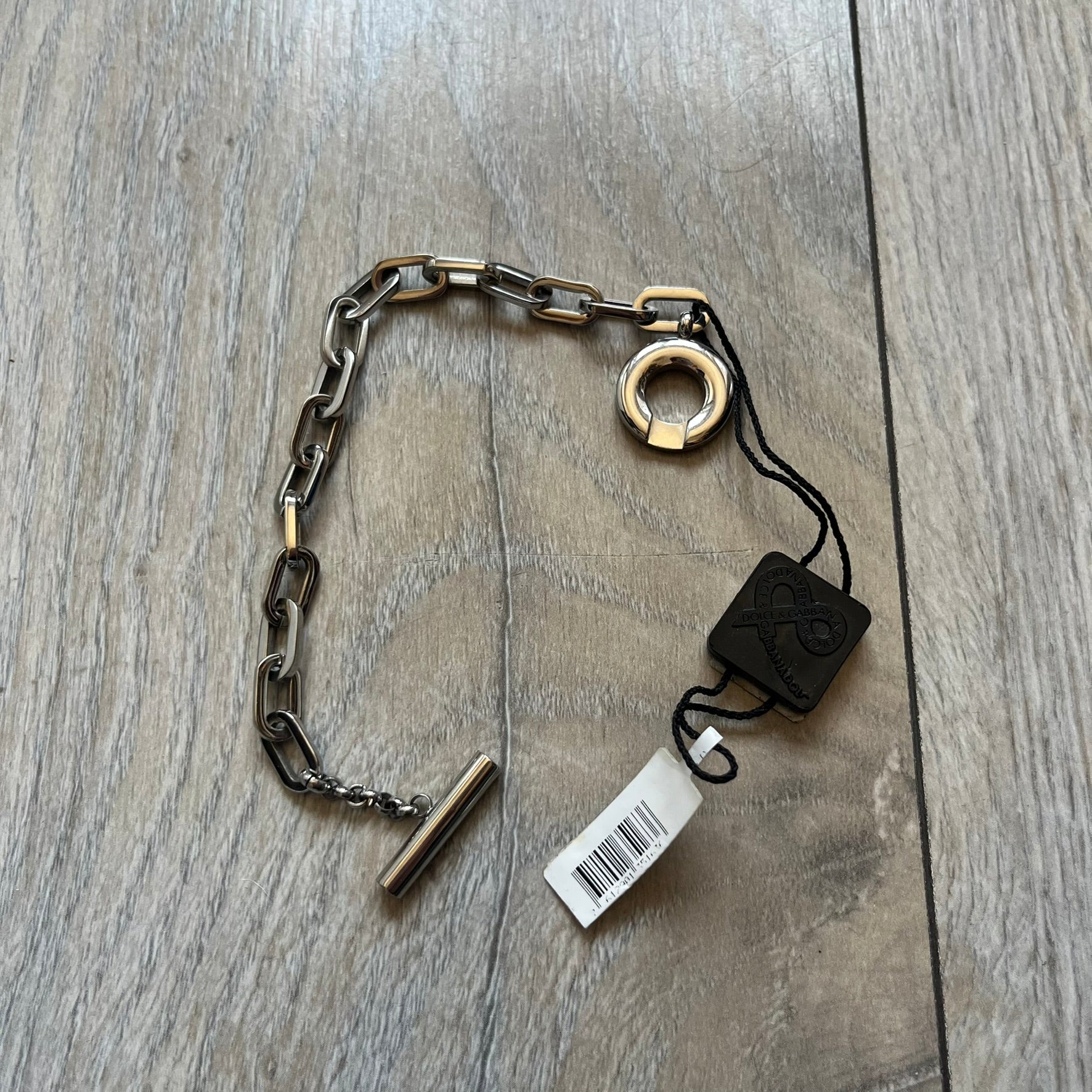 Dolce & Gabbana DJ0162 stainless steel bracelet designed as part of a multi-bracelet watch set, where three bracelets were supplied with the original watch. The piece features a paperclip chain construction and a T-bar clasp fastening. D&G branding appears engraved on the T-bar and on the circular ring element of the clasp.