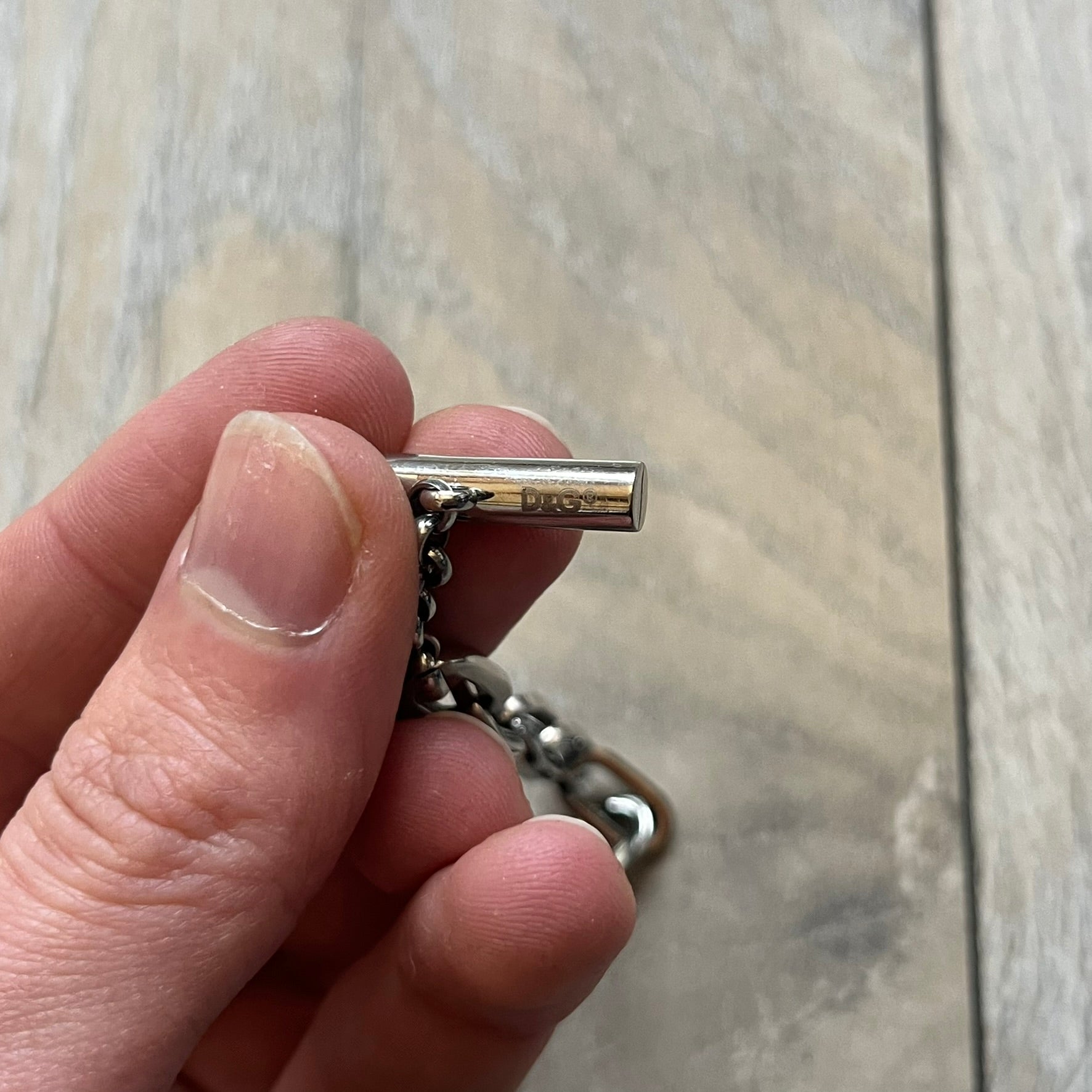 Dolce & Gabbana DJ0162 stainless steel bracelet designed as part of a multi-bracelet watch set, where three bracelets were supplied with the original watch. The piece features a paperclip chain construction and a T-bar clasp fastening. D&G branding appears engraved on the T-bar and on the circular ring element of the clasp.