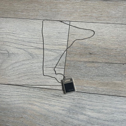 Dolce & Gabbana DJ0430 Black Stone Necklace is a 2000s necklace featuring a stainless steel pendant with a square black stone insert on the front. The lower right corner of the stone is engraved with a D&G logo. It comes with a steel ball chain.