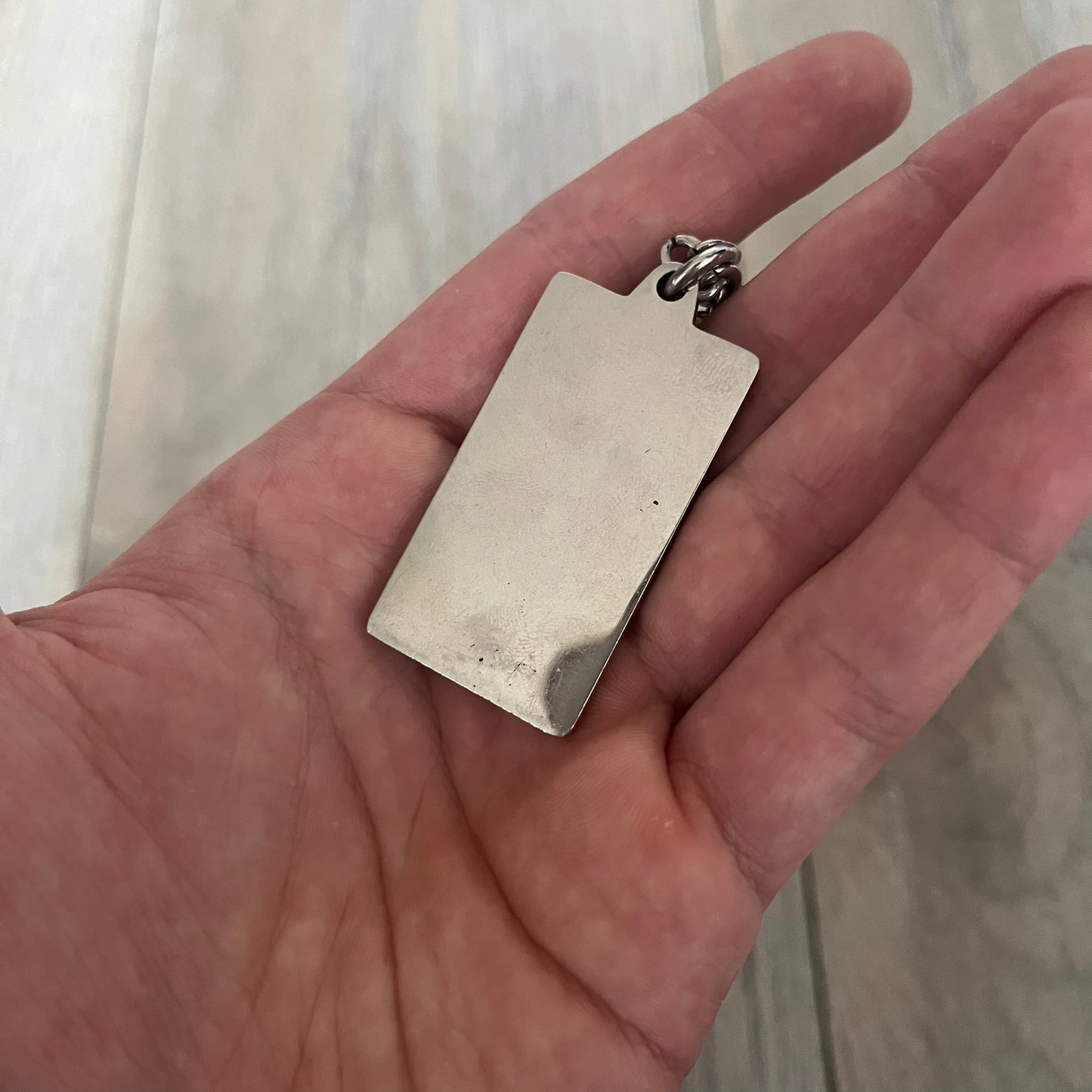 Dolce &amp; Gabbana Propaganda Dog Tag Necklace, featuring a silver stainless steel square tag with four visible screws and the D&amp;G logo engraved on the front. The tag hangs from a durable cable chain, combining sturdy construction with clean, industrial-inspired detailing.