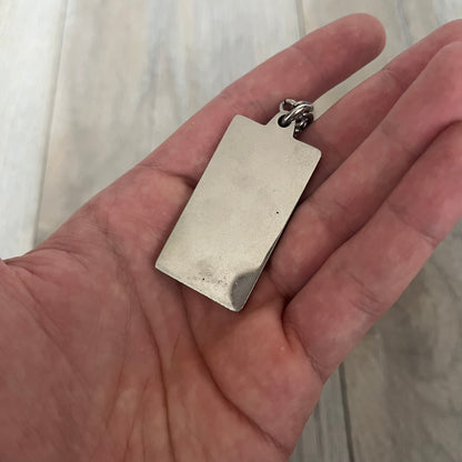 Dolce &amp; Gabbana Propaganda Dog Tag Necklace, featuring a silver stainless steel square tag with four visible screws and the D&amp;G logo engraved on the front. The tag hangs from a durable cable chain, combining sturdy construction with clean, industrial-inspired detailing.