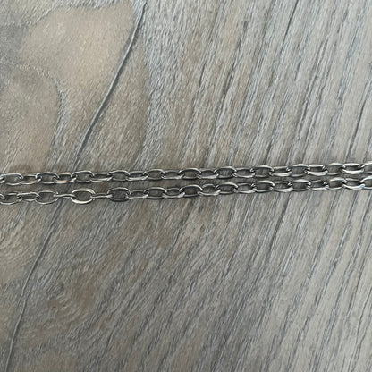 Dolce &amp; Gabbana Propaganda Dog Tag Necklace, featuring a silver stainless steel square tag with four visible screws and the D&amp;G logo engraved on the front. The tag hangs from a durable cable chain, combining sturdy construction with clean, industrial-inspired detailing.