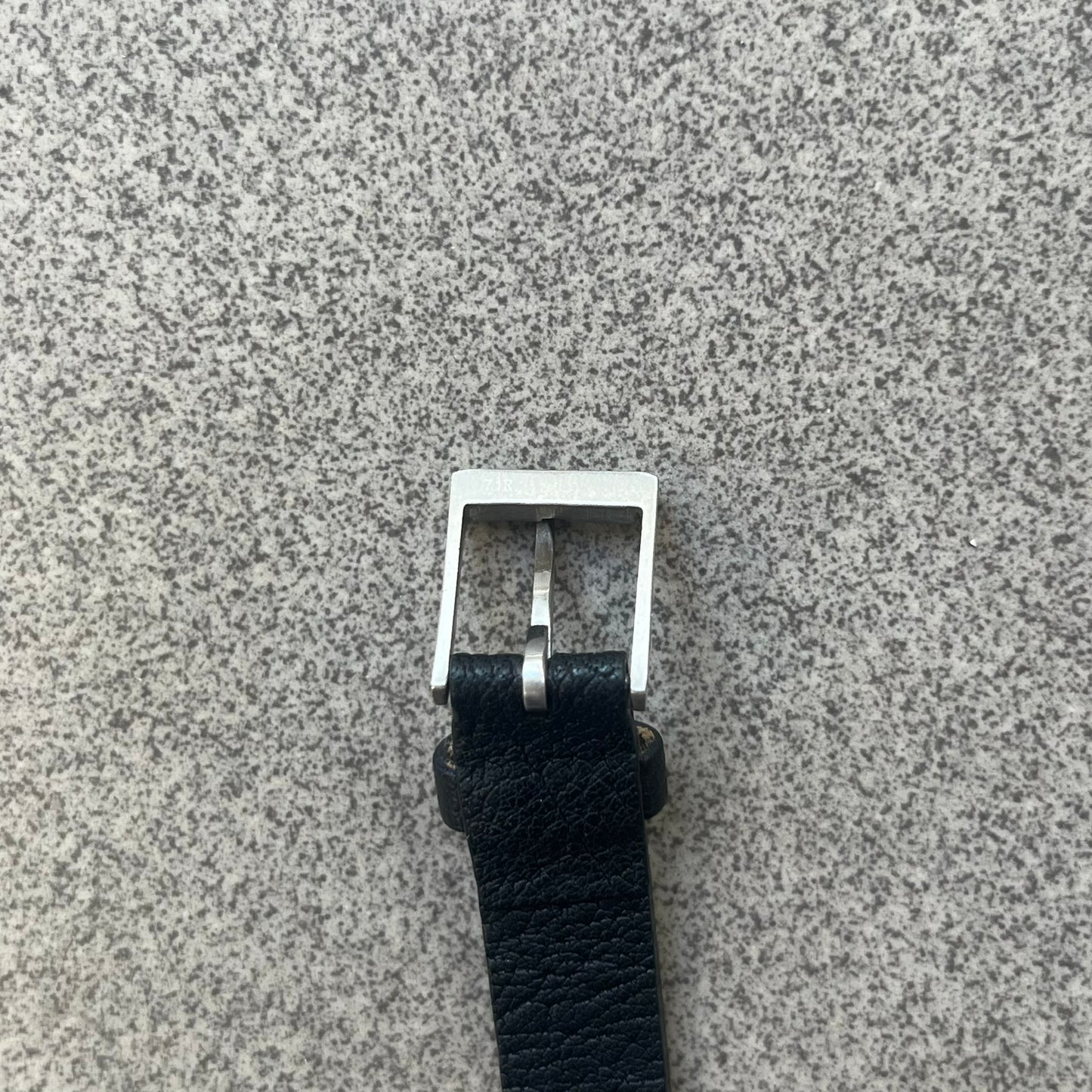 Dolce & Gabbana DJ0574 Black Stone Bracelet is a black leather bracelet featuring a stainless steel central plaque. The plaque includes a rectangular black stone detail with an engraved D&G logo on the right side. The clasp is also engraved with the D&G logo, completing the minimal design.
