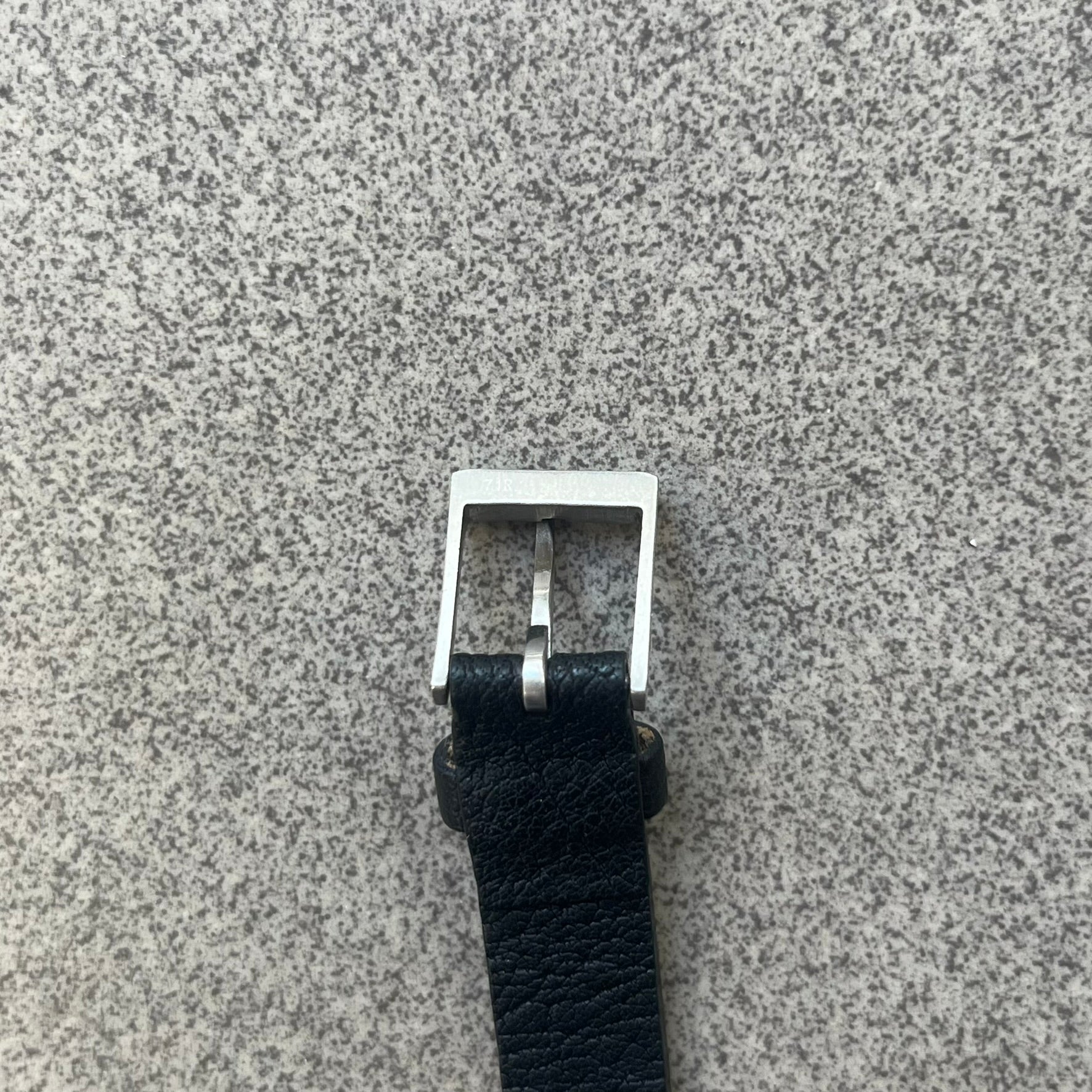Dolce & Gabbana DJ0574 Black Stone Bracelet is a black leather bracelet featuring a stainless steel central plaque. The plaque includes a rectangular black stone detail with an engraved D&G logo on the right side. The clasp is also engraved with the D&G logo, completing the minimal design.
