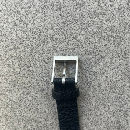 Dolce & Gabbana DJ0574 Black Stone Bracelet is a black leather bracelet featuring a stainless steel central plaque. The plaque includes a rectangular black stone detail with an engraved D&G logo on the right side. The clasp is also engraved with the D&G logo, completing the minimal design.
