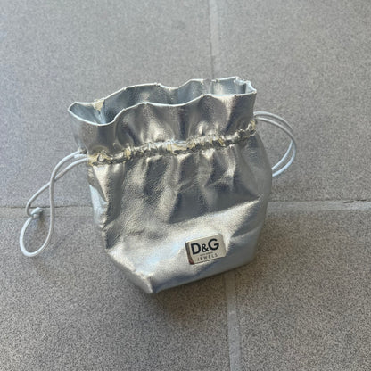 The Dolce &amp; Gabbana Crystal Logo Dog Tag Necklace features a silver-tone ball chain with two pendants: a plain dog tag and a cutout D&amp;G logo adorned with crystals. It has a large clasp engraved with D&amp;G and model markings, from the 2000s.