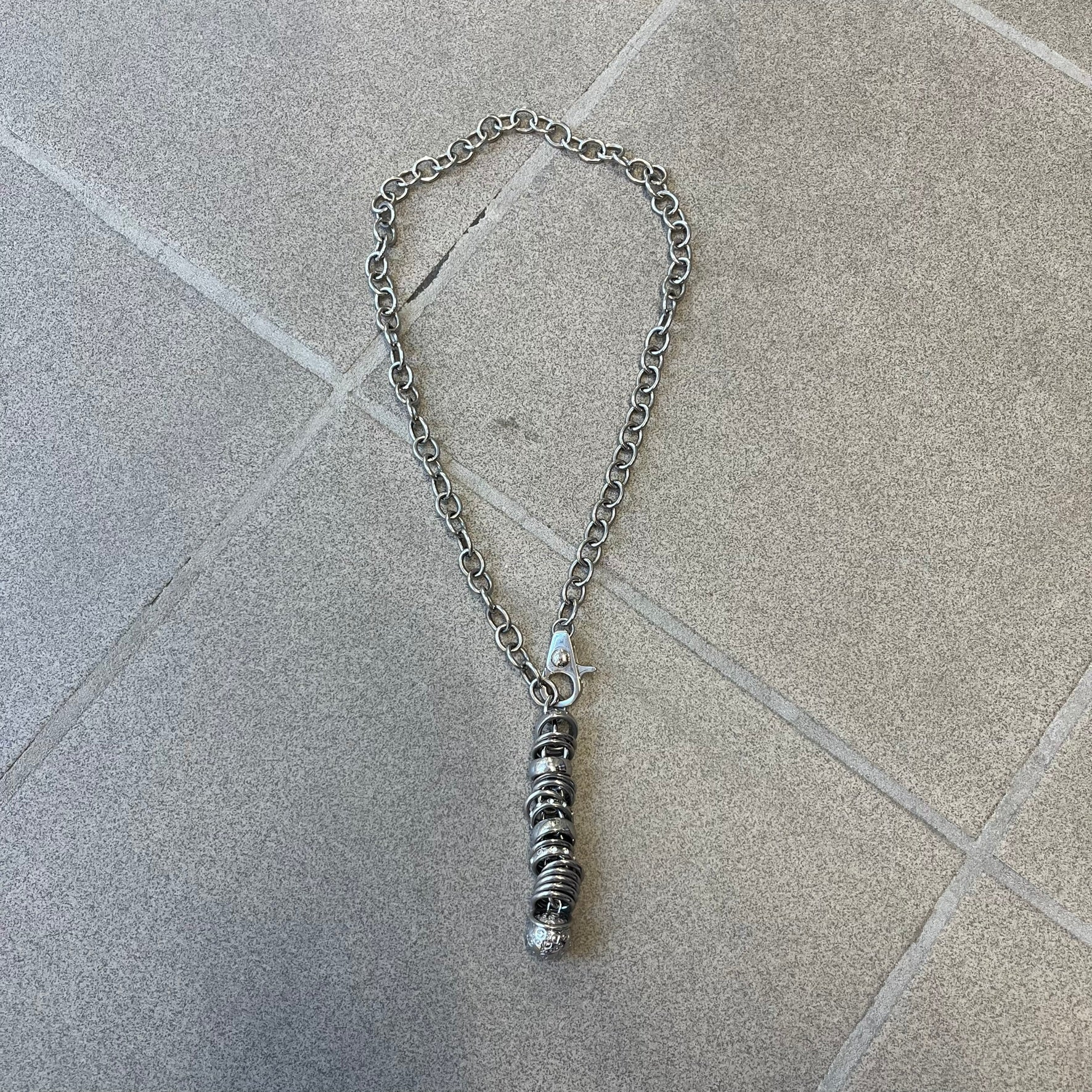 Dolce &amp; Gabbana DJ0776 Crystal Ring Link Necklace features a long stainless steel chain with freely moving rings, including basic loops, D&amp;G-engraved rings and crystal-set rings. The necklace has a large clasp, while the end is finished with a ball featuring D&amp;G logos all around it.