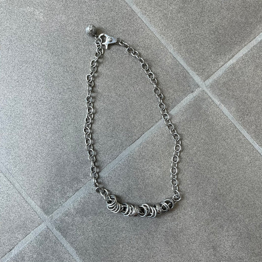 Dolce &amp; Gabbana DJ0776 Crystal Ring Link Necklace features a long stainless steel chain with freely moving rings, including basic loops, D&amp;G-engraved rings and crystal-set rings. The necklace has a large clasp, while the end is finished with a ball featuring D&amp;G logos all around it.