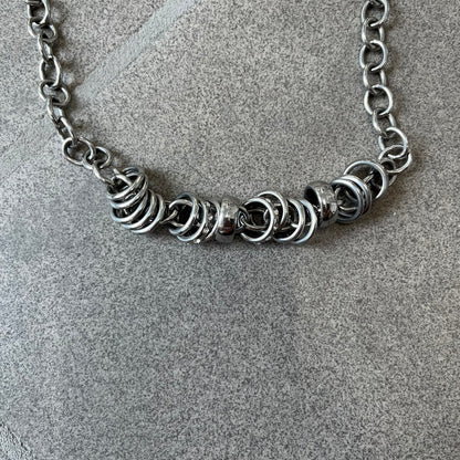 Dolce &amp; Gabbana DJ0776 Crystal Ring Link Necklace features a long stainless steel chain with freely moving rings, including basic loops, D&amp;G-engraved rings and crystal-set rings. The necklace has a large clasp, while the end is finished with a ball featuring D&amp;G logos all around it.