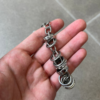 Dolce &amp; Gabbana DJ0776 Crystal Ring Link Necklace features a long stainless steel chain with freely moving rings, including basic loops, D&amp;G-engraved rings and crystal-set rings. The necklace has a large clasp, while the end is finished with a ball featuring D&amp;G logos all around it.