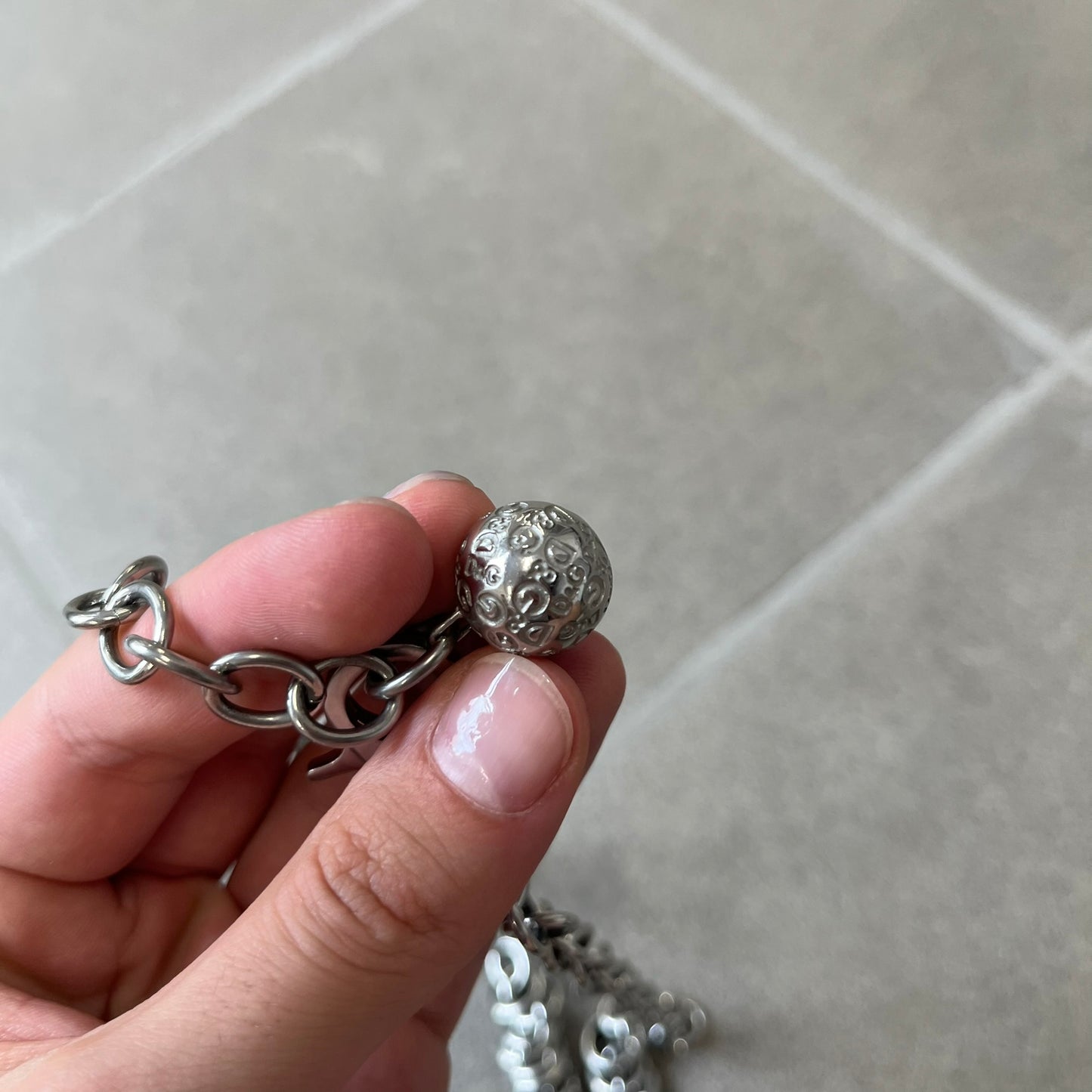 Dolce &amp; Gabbana DJ0776 Crystal Ring Link Necklace features a long stainless steel chain with freely moving rings, including basic loops, D&amp;G-engraved rings and crystal-set rings. The necklace has a large clasp, while the end is finished with a ball featuring D&amp;G logos all around it.