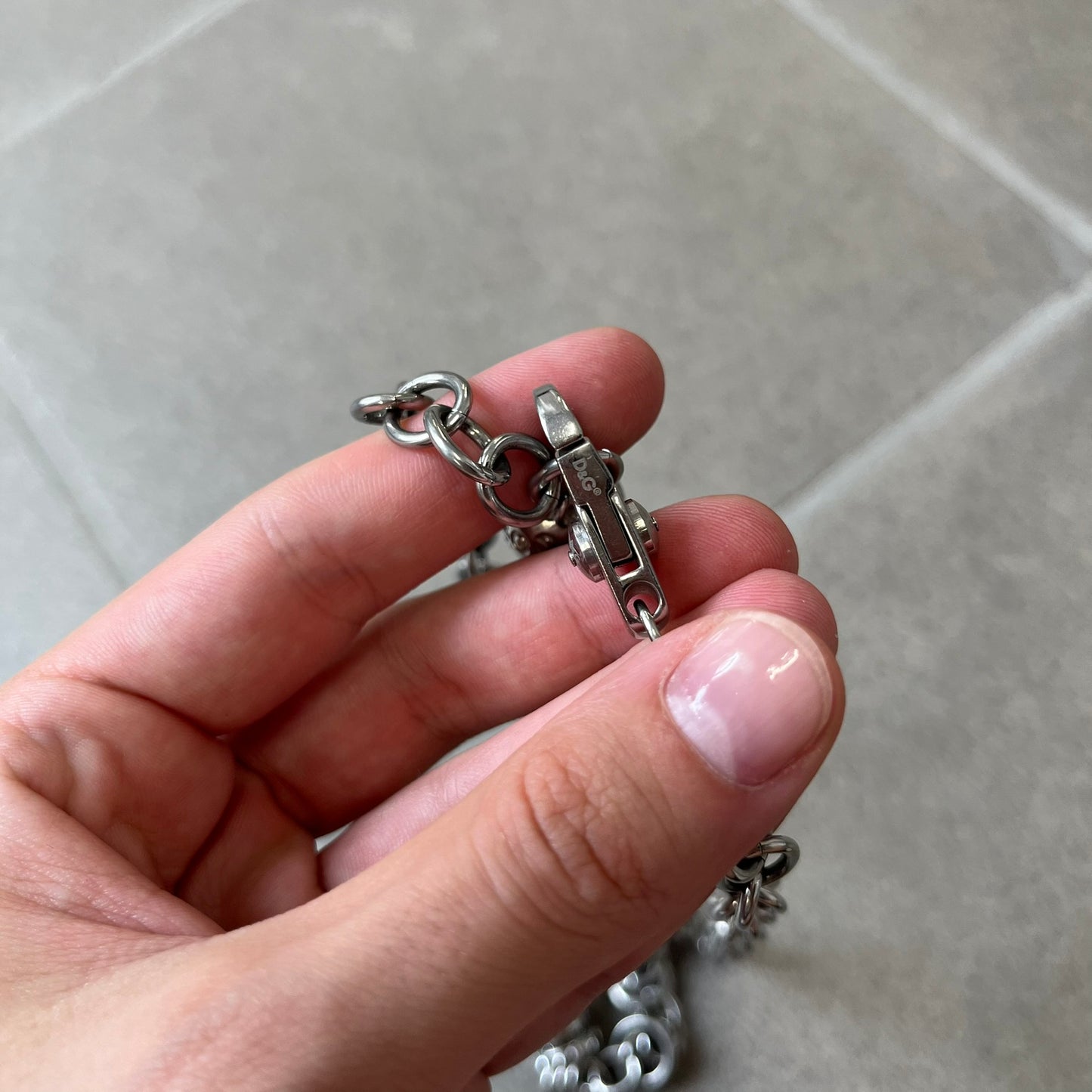 Dolce &amp; Gabbana DJ0776 Crystal Ring Link Necklace features a long stainless steel chain with freely moving rings, including basic loops, D&amp;G-engraved rings and crystal-set rings. The necklace has a large clasp, while the end is finished with a ball featuring D&amp;G logos all around it.