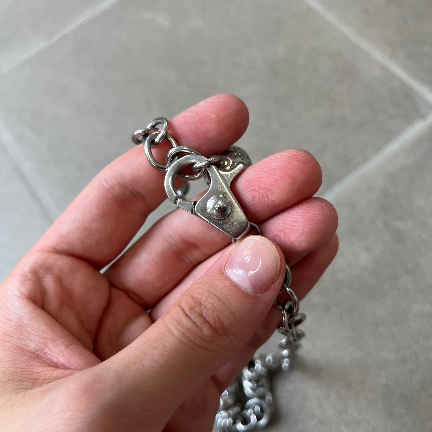 Dolce &amp; Gabbana DJ0776 Crystal Ring Link Necklace features a long stainless steel chain with freely moving rings, including basic loops, D&amp;G-engraved rings and crystal-set rings. The necklace has a large clasp, while the end is finished with a ball featuring D&amp;G logos all around it.