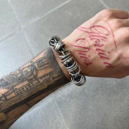 Dolce &amp; Gabbana DJ0777 Crystal Ring Link Bracelet features a stainless steel chain with freely moving rings, including basic loops, D&amp;G-engraved rings and crystal-set rings. The bracelet has a large clasp, while the end is finished with a ball featuring D&amp;G logos all around it.