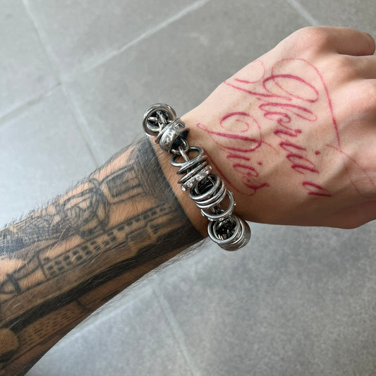 Dolce &amp; Gabbana DJ0777 Crystal Ring Link Bracelet features a stainless steel chain with freely moving rings, including basic loops, D&amp;G-engraved rings and crystal-set rings. The bracelet has a large clasp, while the end is finished with a ball featuring D&amp;G logos all around it.