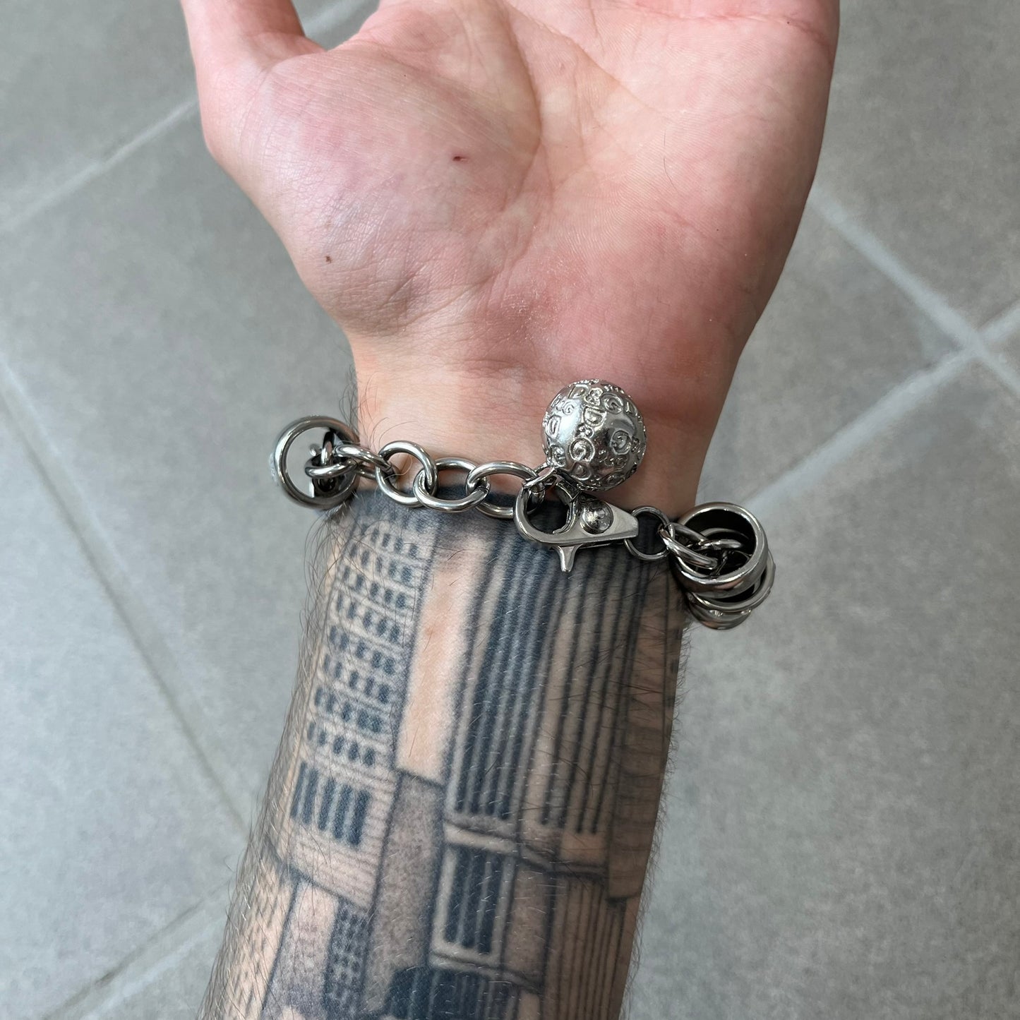 Dolce &amp; Gabbana DJ0777 Crystal Ring Link Bracelet features a stainless steel chain with freely moving rings, including basic loops, D&amp;G-engraved rings and crystal-set rings. The bracelet has a large clasp, while the end is finished with a ball featuring D&amp;G logos all around it.