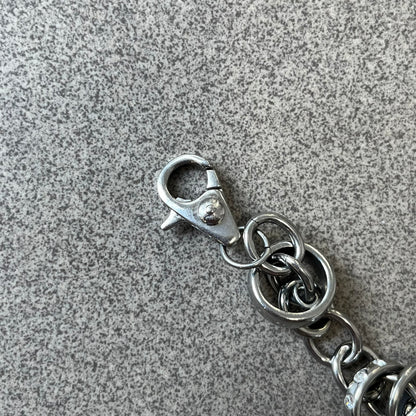 Dolce &amp; Gabbana DJ0777 Crystal Ring Link Bracelet features a stainless steel chain with freely moving rings, including basic loops, D&amp;G-engraved rings and crystal-set rings. The bracelet has a large clasp, while the end is finished with a ball featuring D&amp;G logos all around it.