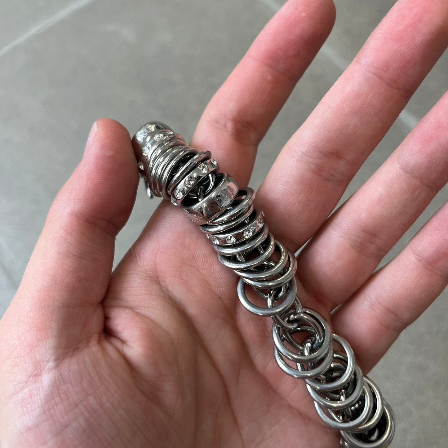 Dolce &amp; Gabbana DJ0777 Crystal Ring Link Bracelet features a stainless steel chain with freely moving rings, including basic loops, D&amp;G-engraved rings and crystal-set rings. The bracelet has a large clasp, while the end is finished with a ball featuring D&amp;G logos all around it.