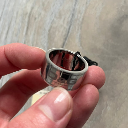Dolce & Gabbana DJ0836 Logo Ring is a silver-tone stainless steel ring featuring engraved D&G logos in the center. The top and bottom edges have engraved rope-style lines running continuously around the band, giving it a subtle textured detail.