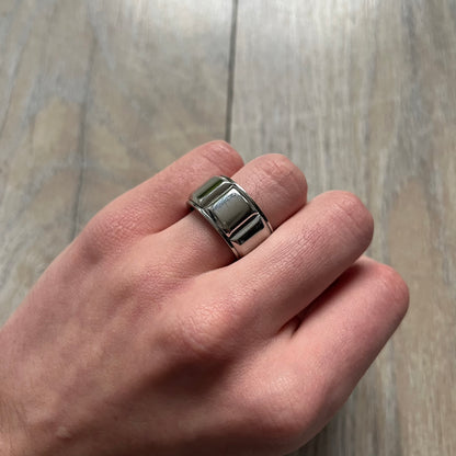 Dolce & Gabbana DJ0836 Ring is made from silver-tone metal and features three raised square elements set across the top. Next to the squares, there is a small engraved D&G logo. The ring has a clean, minimal design and is marked with model code DJ0836.