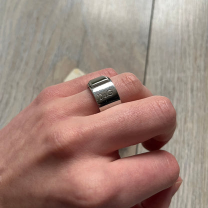 Dolce & Gabbana DJ0836 Ring is made from silver-tone metal and features three raised square elements set across the top. Next to the squares, there is a small engraved D&G logo. The ring has a clean, minimal design and is marked with model code DJ0836.