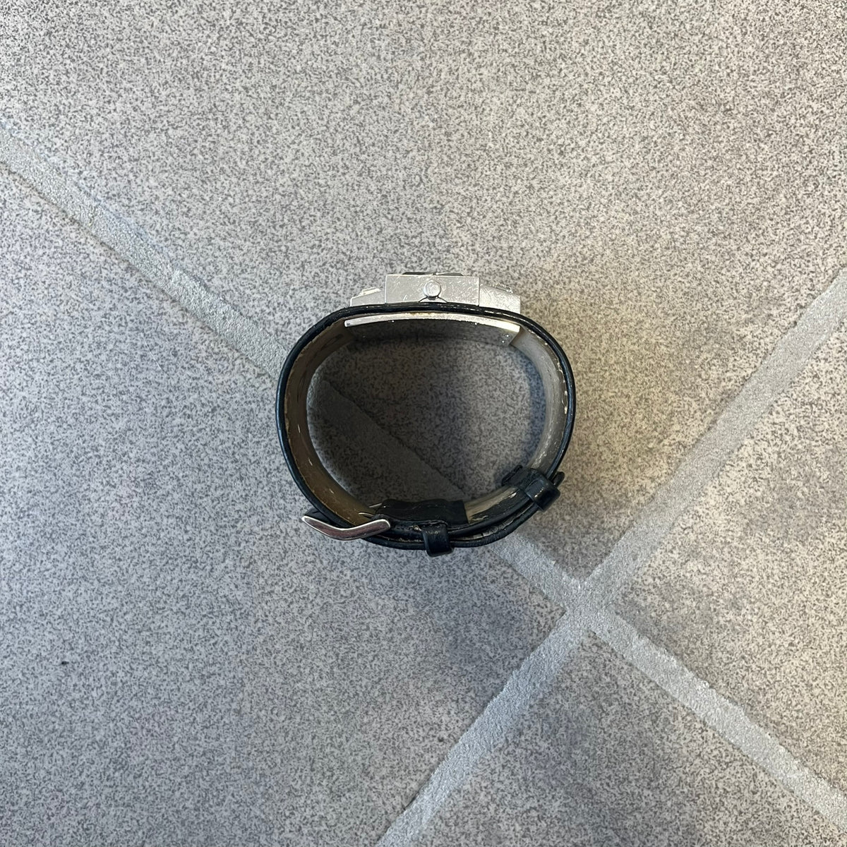 Dolce & Gabbana DW0174 Black Leather Analog Watch features a stainless steel dial composed of multiple squares, including smaller squares set with clear and black crystals, one bearing a D&G logo, and a larger square housing the watch hands. It is water resistant to 3 ATM.