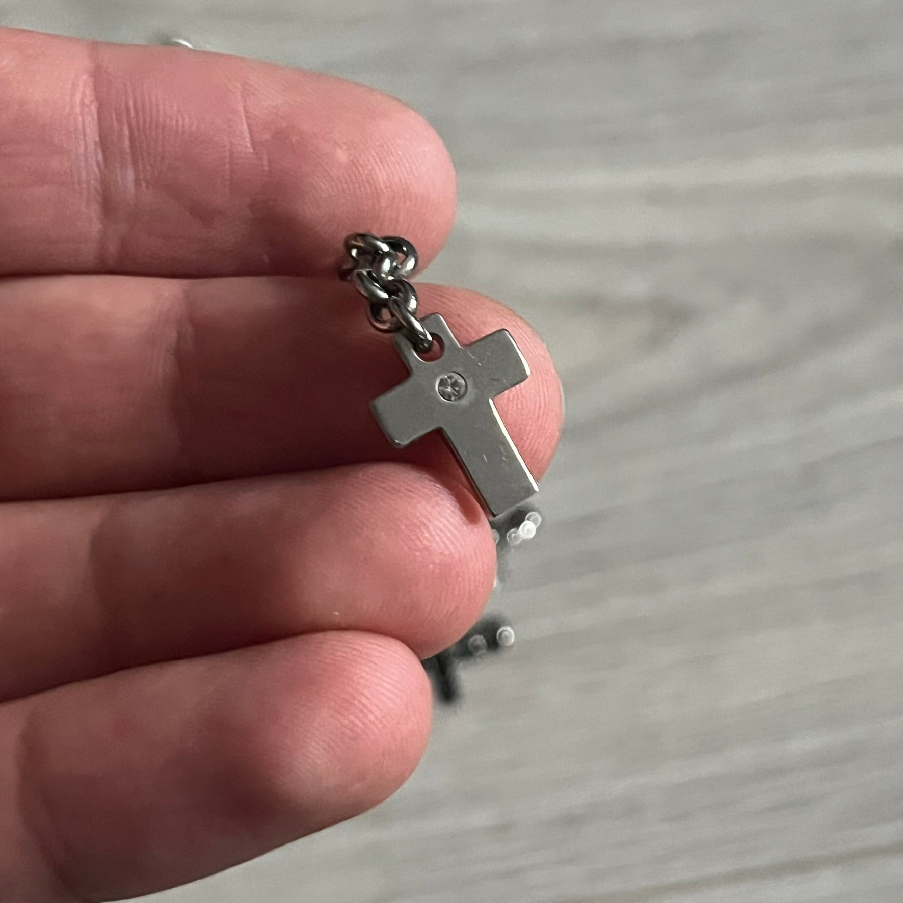 Dolce & Gabbana Dangle Drop Cross Earrings. Pair of earrings featuring three crosses of varying lengths on each, including one with black stones, one with clear stones, and one full metal cross with a D&G logo and a small clear stone. Comes with original box and dustbag