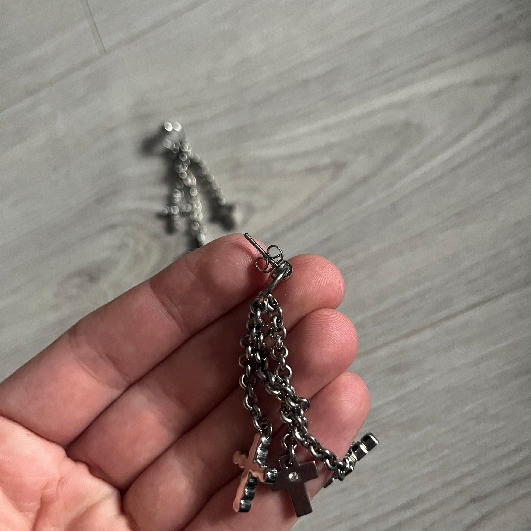 Dolce & Gabbana Dangle Drop Cross Earrings. Pair of earrings featuring three crosses of varying lengths on each, including one with black stones, one with clear stones, and one full metal cross with a D&G logo and a small clear stone. Comes with original box and dustbag