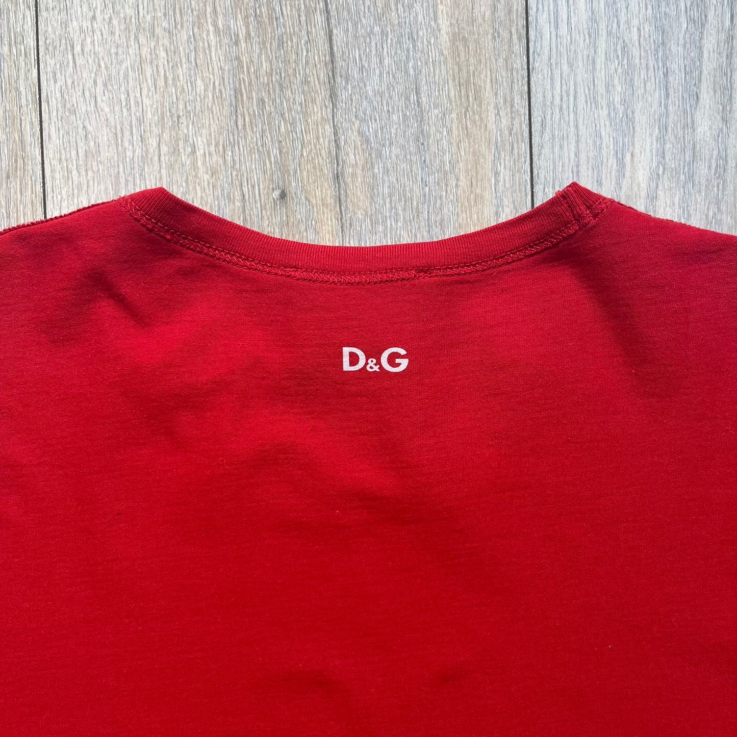 Dolce &amp; Gabbana Fall 2011 tee in vibrant red featuring a simple “Drink Coca-Cola” logo on the chest. Designed with an inside-out stitching aesthetic and a subtle back logo under the collar. A unique, collectible tee that merges casual branding with high-fashion flair.