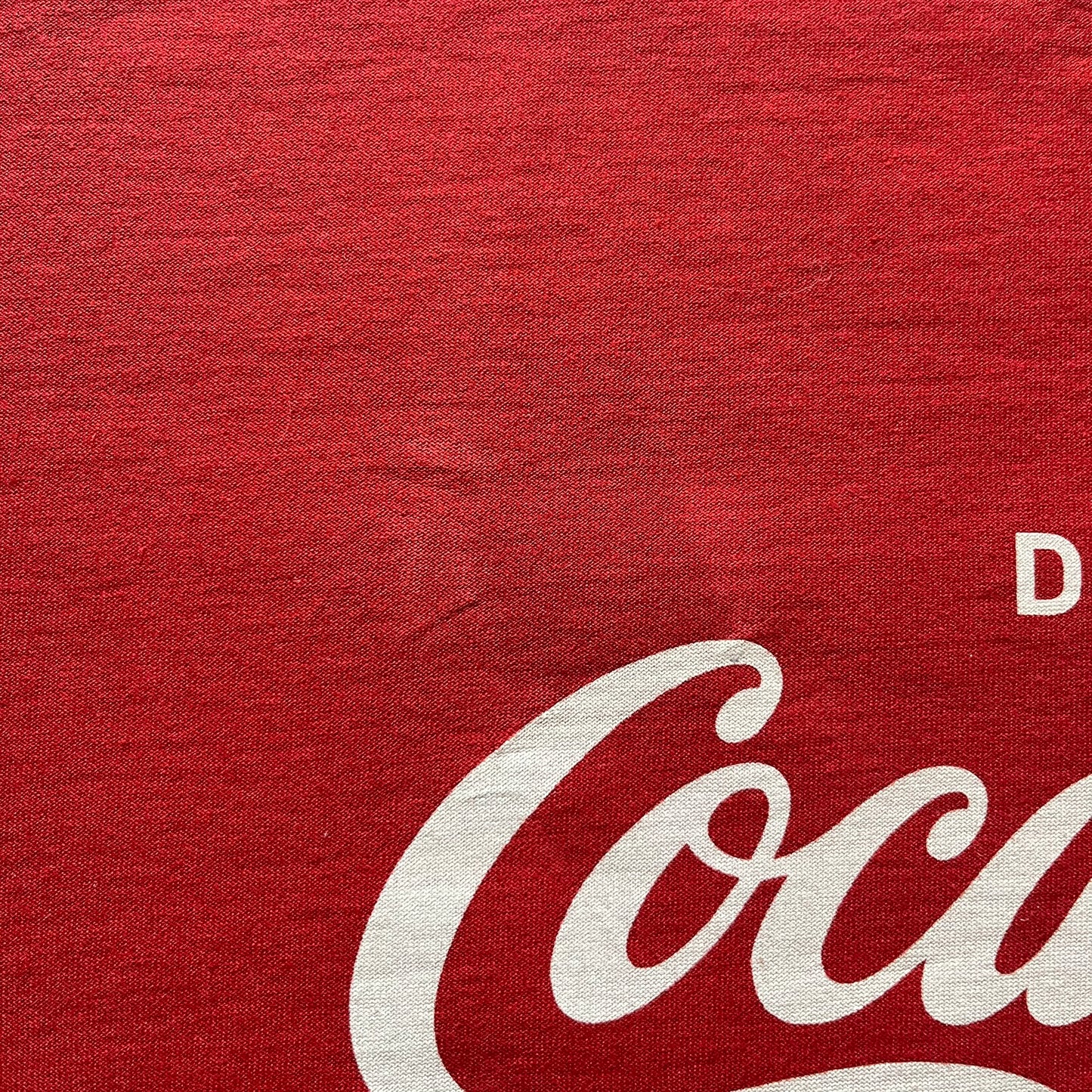 Dolce &amp; Gabbana Fall 2011 tee in vibrant red featuring a simple “Drink Coca-Cola” logo on the chest. Designed with an inside-out stitching aesthetic and a subtle back logo under the collar. A unique, collectible tee that merges casual branding with high-fashion flair.