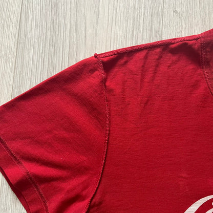 Dolce &amp; Gabbana Fall 2011 tee in vibrant red featuring a simple “Drink Coca-Cola” logo on the chest. Designed with an inside-out stitching aesthetic and a subtle back logo under the collar. A unique, collectible tee that merges casual branding with high-fashion flair.