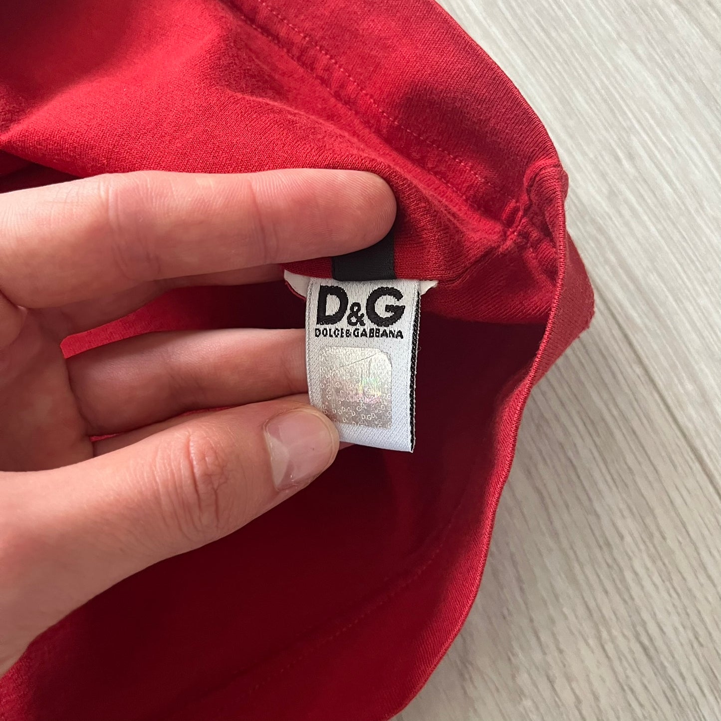 Dolce &amp; Gabbana Fall 2011 tee in vibrant red featuring a simple “Drink Coca-Cola” logo on the chest. Designed with an inside-out stitching aesthetic and a subtle back logo under the collar. A unique, collectible tee that merges casual branding with high-fashion flair.