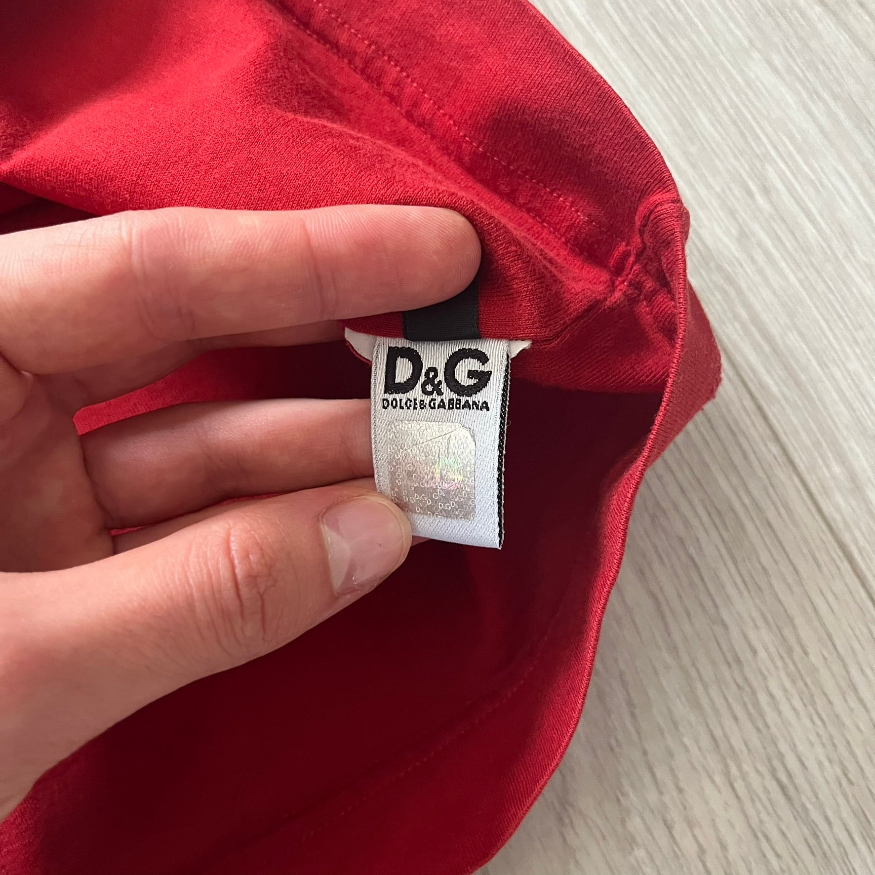 Dolce &amp; Gabbana Fall 2011 tee in vibrant red featuring a simple “Drink Coca-Cola” logo on the chest. Designed with an inside-out stitching aesthetic and a subtle back logo under the collar. A unique, collectible tee that merges casual branding with high-fashion flair.