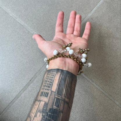 Dolce &amp; Gabbana Gold Charm Cross DJ0250 Bracelet features a gold-tone chain bracelet with white bead charms, six cross-shaped charms made from circular elements, and a D&amp;G logo charm. The bracelet has a gold-tone metal construction.&nbsp;