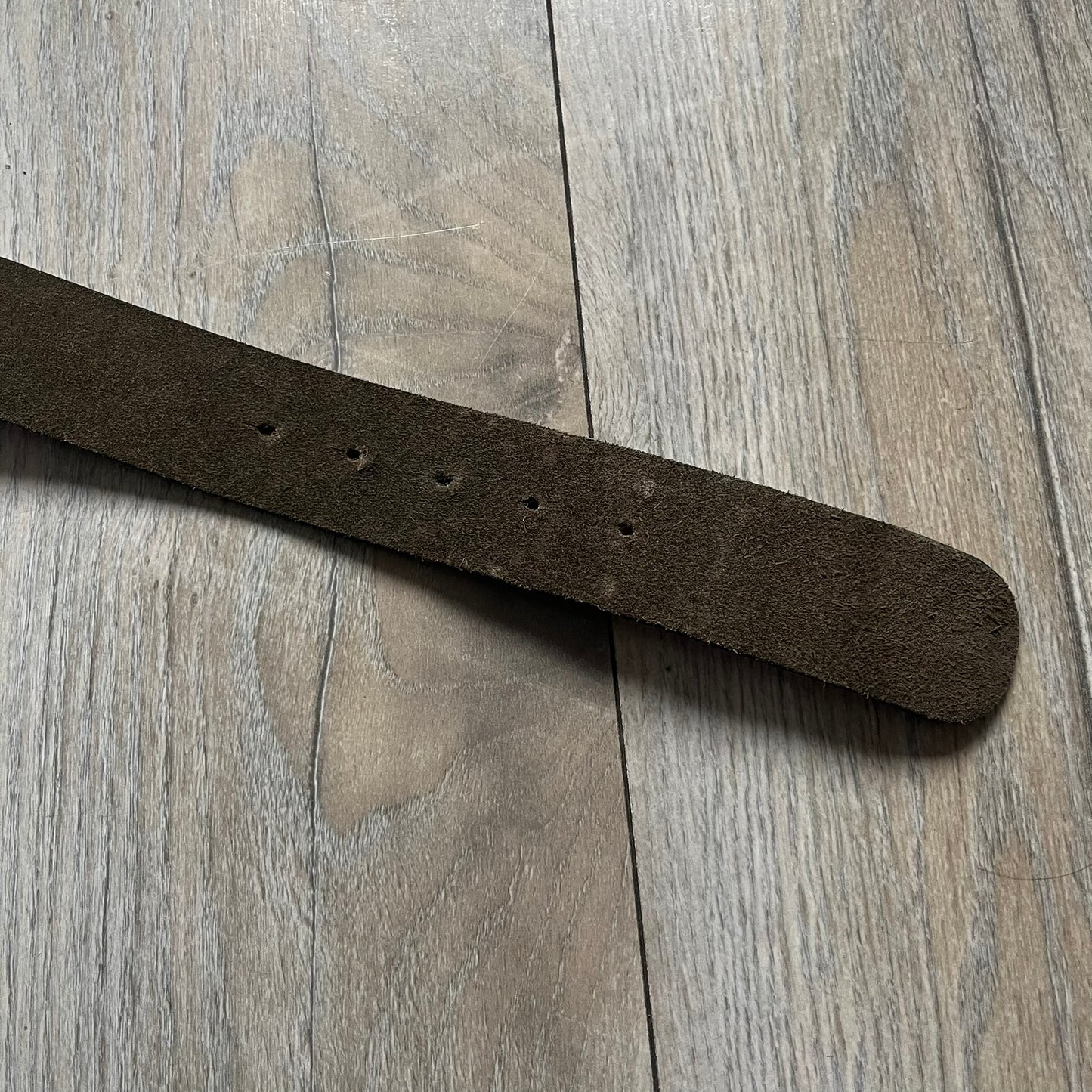 Dolce & Gabbana Green Suede Hearts Belt is made from very dark green suede with an orange leather interior featuring large dot detailing. The buckle is a metal D&G logo surrounded by eight heart shapes pointing outward, all finished in a dark, aged-looking metal tone. The belt comes with the original hologram tag attached.