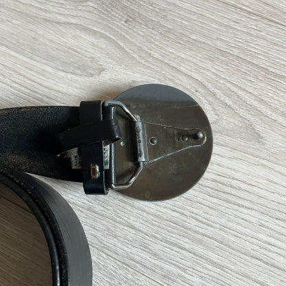 2000's Dolce & Gabbana black leather belt featuring a circular dark silver-tone metal buckle with the Italian flag and D&G logo in the center. The buckle is bordered by a navy ring with engraved text reading “Project And Design Conceived In Italy By Dolce & Gabbana”.