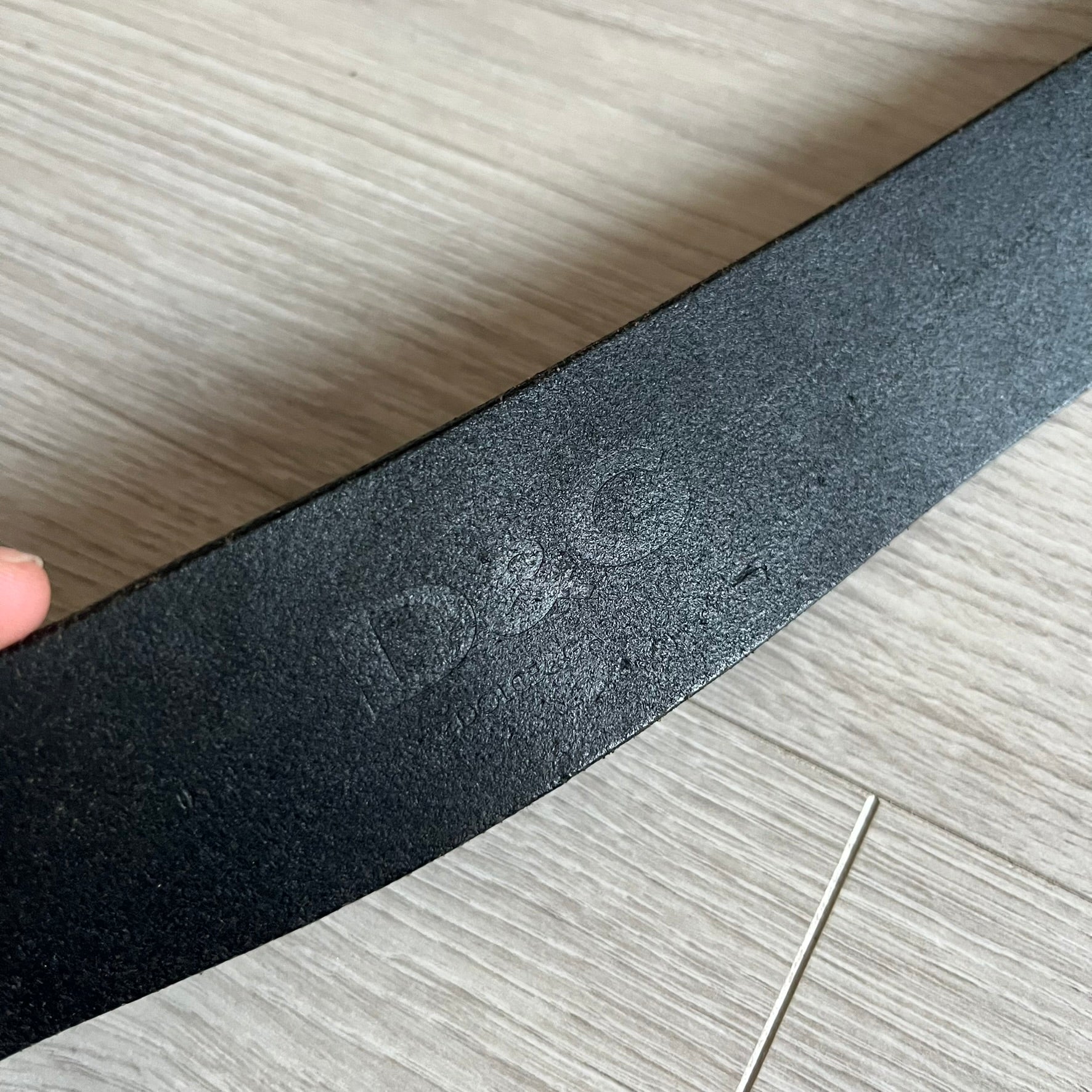 2000's Dolce & Gabbana black leather belt featuring a circular dark silver-tone metal buckle with the Italian flag and D&G logo in the center. The buckle is bordered by a navy ring with engraved text reading “Project And Design Conceived In Italy By Dolce & Gabbana”.