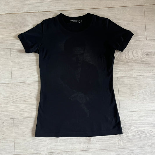 This Dolce &amp; Gabbana James Dean Black Tee features a premium Italian-made cotton construction with a front portrait of James. The design includes pretty big white/grey “James Dean” text across the upper back. The t-shirt celebrates the lasting influence of James Dean, a defining figure of mid-century cinema.