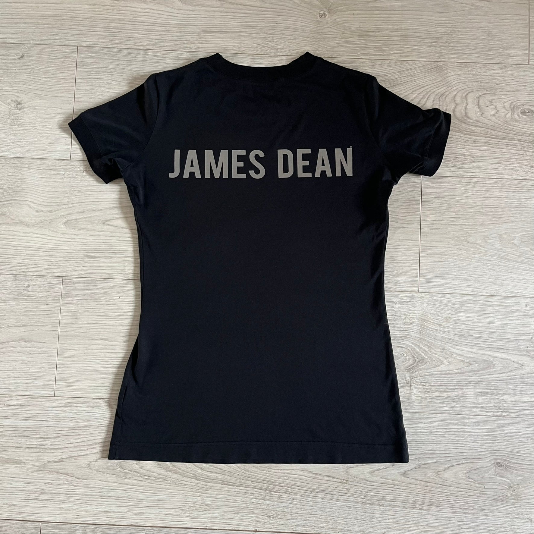 This Dolce &amp; Gabbana James Dean Black Tee features a premium Italian-made cotton construction with a front portrait of James. The design includes pretty big white/grey “James Dean” text across the upper back. The t-shirt celebrates the lasting influence of James Dean, a defining figure of mid-century cinema.