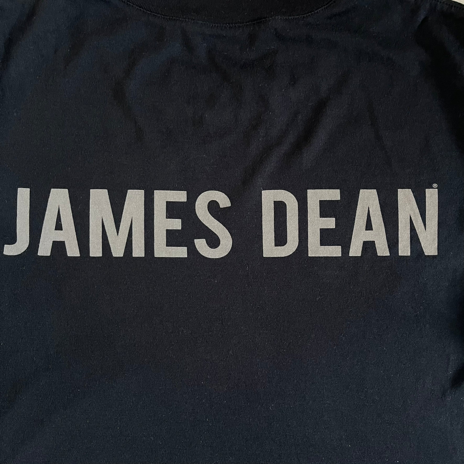 This Dolce &amp; Gabbana James Dean Black Tee features a premium Italian-made cotton construction with a front portrait of James. The design includes pretty big white/grey “James Dean” text across the upper back. The t-shirt celebrates the lasting influence of James Dean, a defining figure of mid-century cinema.
